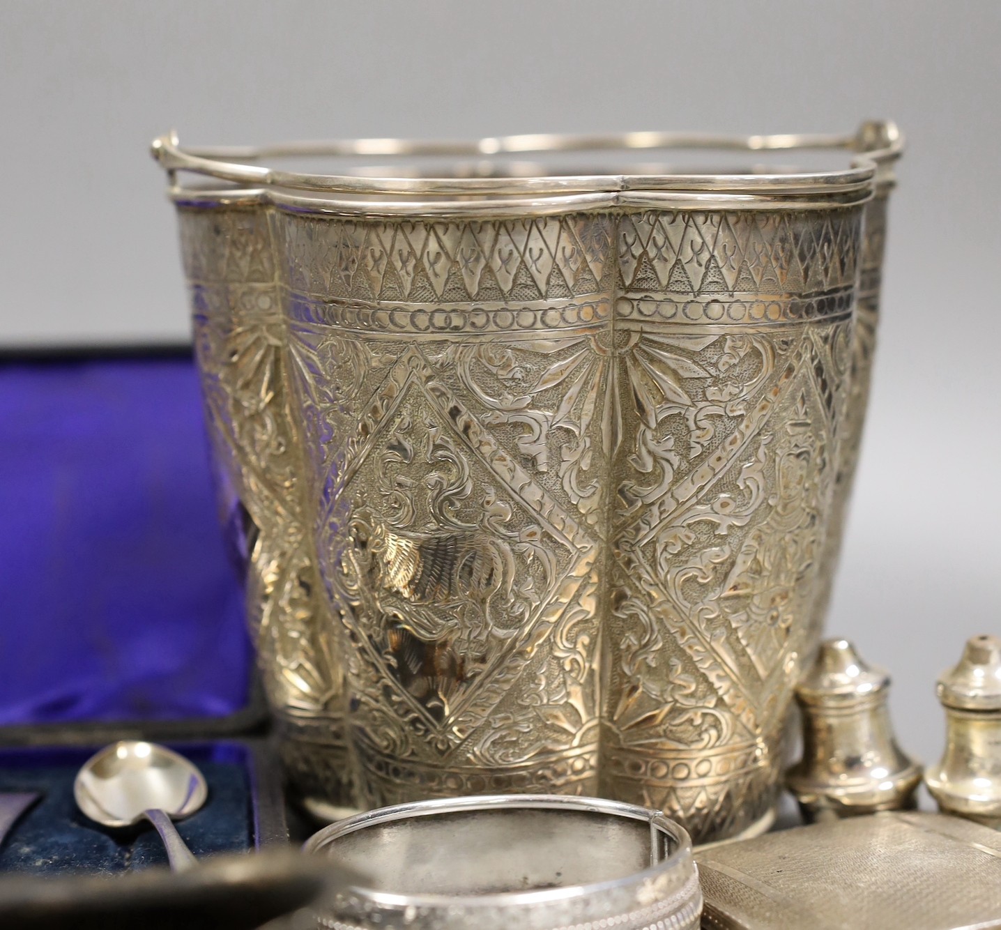 A Siamese sterling two handled ice pail with tongs, height 12.5cm, together with a cased set of six teaspoons with tongs, a silver compact a silver Vogel travelling timepiece on albert chain, three silver condiments, two